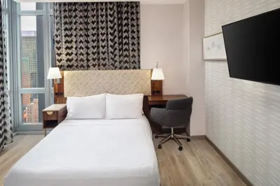 a hotel room with a bed and a desk and a computer at Home2 Suites By Hilton New York Times Square in New York