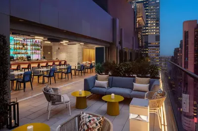 a rooftop patio with tables and couches on a building at Hampton Inn by Hilton New York Times Square in New York