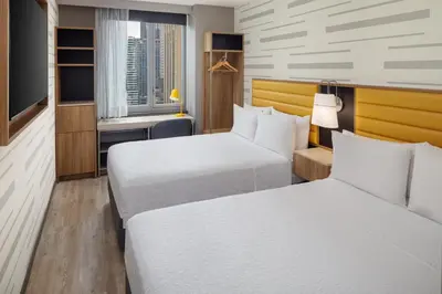 a hotel room with two beds and a television at Hampton Inn by Hilton New York Times Square in New York