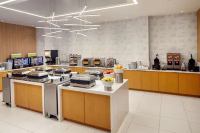 a large kitchen with a counter with a bunch of food at Hampton Inn by Hilton New York Times Square in New York