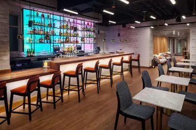 a bar in a restaurant with wooden tables and chairs at Hampton Inn by Hilton New York Times Square in New York