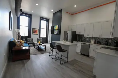 a kitchen with white cabinets and a living room at Downtown Easton in Easton