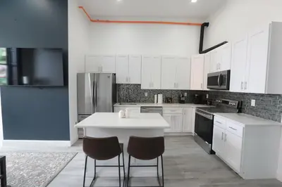 a kitchen with white cabinets and a white table and chairs at Downtown Easton in Easton