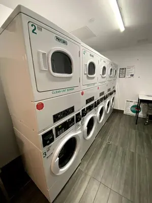 a row of washing machines in a laundry room at Modern Spacious Apartment in Chelsea in New York
