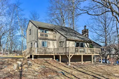 a large house with a deck on top of it at Game Room, Fire Pit Family-Friendly Poconos Haven in East Stroudsburg
