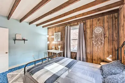 a bedroom with a bed and a wooden wall at Pet-Friendly Mohnton House Near Golf Course! in Mohnton