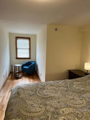 a bedroom with a bed and a chair and a table at J2 Pleasant Queens Size room near St. Peter's hospital & New Brunswick Downtown in New Brunswick