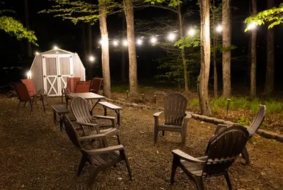 a group of chairs and a table and a shed at night at Cozy Pocono Getaway In Arrowhead Lake in Thornhurst