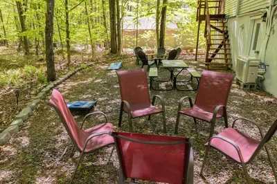 a group of chairs and a table in the woods at Cozy Pocono Getaway In Arrowhead Lake in Thornhurst