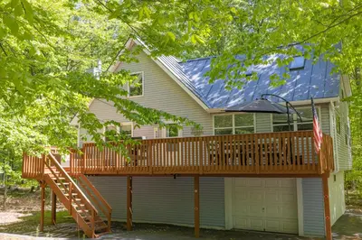 a house with a wooden deck in front of it at Cozy Pocono Getaway In Arrowhead Lake in Thornhurst