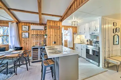 a kitchen with wooden walls and a table and chairs at Stylish and Cozy Cabin, Walking Distance to Big Bass Lake in Gouldsboro