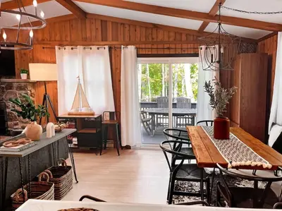a kitchen and dining room with a table and chairs at Stylish and Cozy Cabin, Walking Distance to Big Bass Lake in Gouldsboro