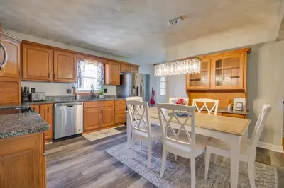 a kitchen with wooden cabinets and a table and chairs at Deck and Grill Convenient Home in Hummelstown in Hummelstown