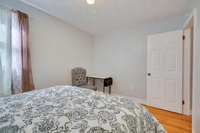 a white bedroom with a bed and a table at Deck and Grill Convenient Home in Hummelstown in Hummelstown