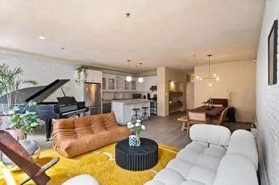 a living room with a couch and a piano at Tribeca Loft Vanderbilt by RoveTravel in New York