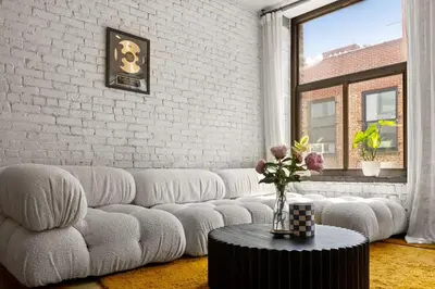 a living room with a white couch and a table at Tribeca Loft Vanderbilt by RoveTravel in New York