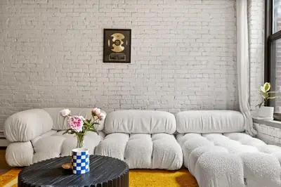 a living room with a white couch and a table at Tribeca Loft Vanderbilt by RoveTravel in New York