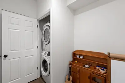 a laundry room with a washer and dryer next to a door at Tribeca Loft Vanderbilt by RoveTravel in New York