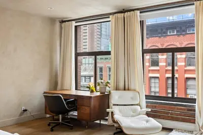 a room with a desk and two chairs in front of a window at Tribeca Loft Vanderbilt by RoveTravel in New York