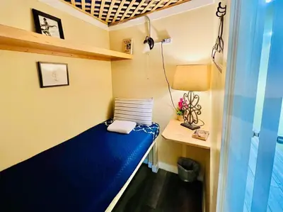 a small room with a blue bed and a desk at New York Spirit Retreats HOSTEL in New York