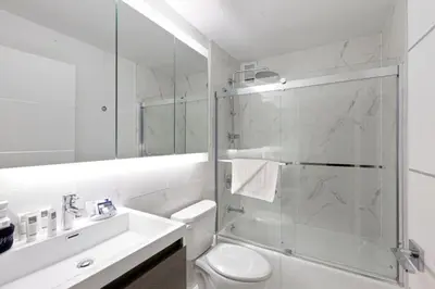 a bathroom with a shower and a toilet and a sink at Rector Place in New York