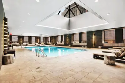 a large pool in a hotel with couches at Rector Place in New York