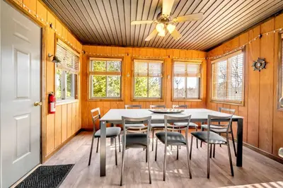 a dining room with a table and chairs and a ceiling fan at Steps To The Lake House, Hot tub, Game room, Deck in Albrightsville