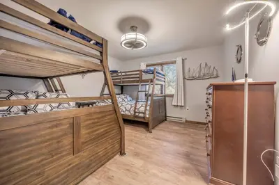 a bedroom with two bunk beds and a desk at Steps To The Lake House, Hot tub, Game room, Deck in Albrightsville