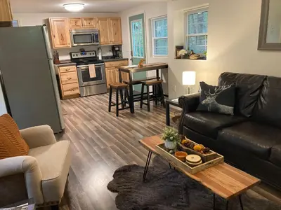 a living room with a couch and a table at Peaceful Seasonal Wooded Cottage close to everything in Tafton
