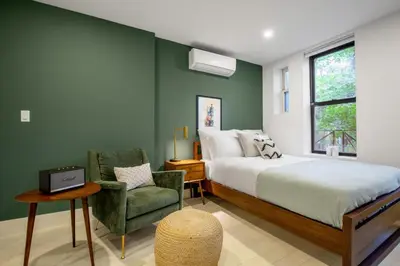 a bedroom with a bed and a chair and a window at E Village Studio w renovated virtual doorman NYC-316 in New York