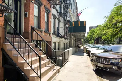a street with cars parked on the side of a building at E Village Studio w renovated virtual doorman NYC-316 in New York