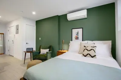 a bedroom with a large bed and a green wall at E Village Studio w renovated virtual doorman NYC-316 in New York