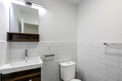 a bathroom with a sink and a toilet and a mirror at E Village Studio w renovated virtual doorman NYC-316 in New York