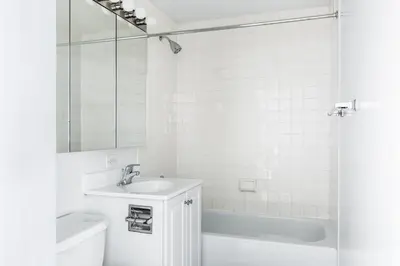 a white bathroom with a sink and a tub at Chelsea 1BR w Gym nr Penn Station MSG NYC-528 in New York