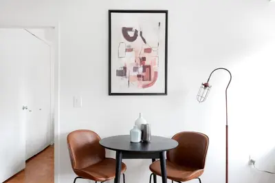 a dining room with a table and chairs and a lamp at Chelsea 1BR w Gym nr Penn Station MSG NYC-528 in New York