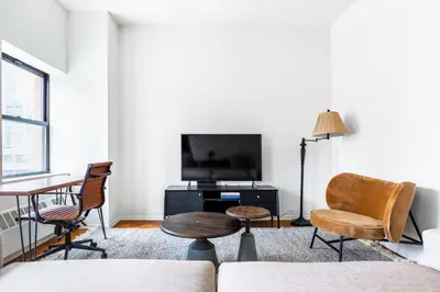 a living room with a tv and a table and chairs at Chelsea 1BR w Gym nr Penn Station MSG NYC-528 in New York