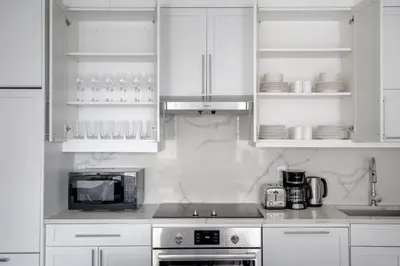 a kitchen with white cabinets and a microwave at UWS 2br w elevator doorman gym nr Central Park NYC-952 in New York