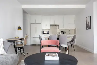 a living room with a table and chairs and a kitchen at UWS 2br w elevator doorman gym nr Central Park NYC-952 in New York