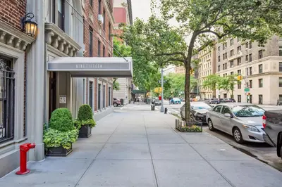 a sidewalk in a city with a red fire hydrant at UWS 2br w elevator doorman gym nr Central Park NYC-952 in New York