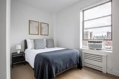 a white bedroom with a bed and a window at UWS 2br w elevator doorman gym nr Central Park NYC-952 in New York