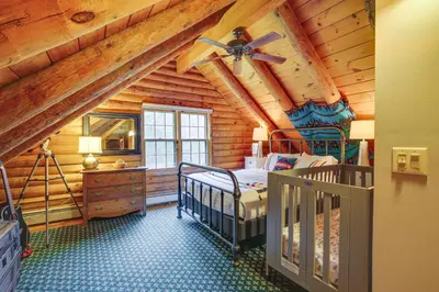 a bedroom with a bed in a log cabin at Accord Vacation Rental with Pool and Hot Tub! in Accord