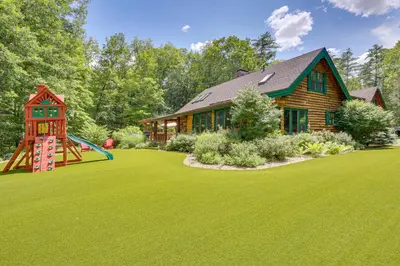 a log home with a playground and a house at Accord Vacation Rental with Pool and Hot Tub! in Accord
