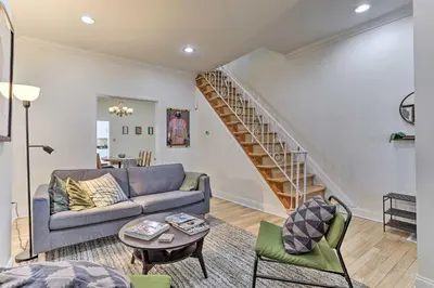 a living room with a couch and a staircase at Philadelphia Home Rental Near Center City! in Philadelphia