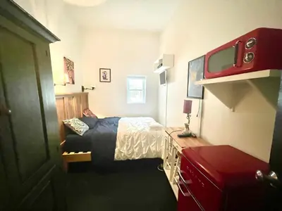 a small bedroom with a bed and a tv at Beautiful and spacious apartment in Times Square! in New York