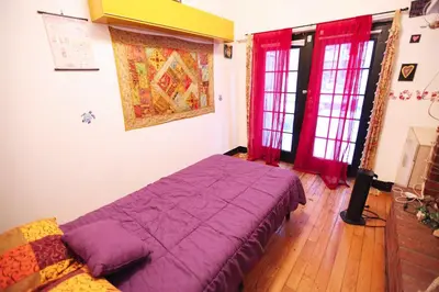 a bedroom with a purple bed and red curtains at Beautiful and spacious apartment in Times Square! in New York