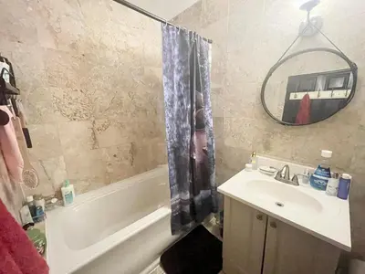 a bathroom with a sink and a tub and a mirror at Beautiful and spacious apartment in Times Square! in New York