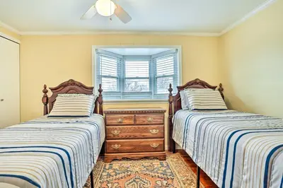 two beds in a room with a dresser and a window at Family Vacation Rental 18 Mi to Philadelphia in Gibbstown