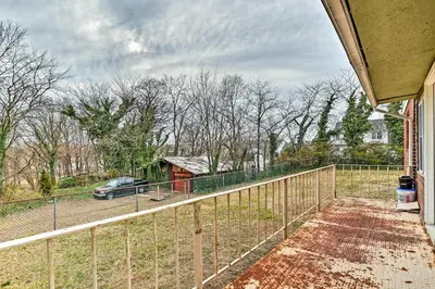 a fence on the side of a house with a car at Family Vacation Rental 18 Mi to Philadelphia in Gibbstown