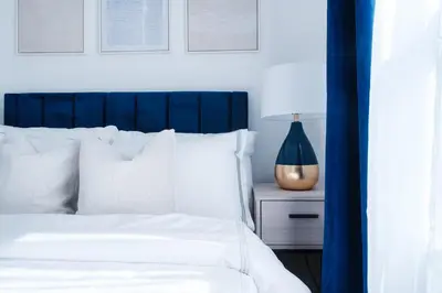a bedroom with a white bed with a blue headboard at 74-4A 2BR 2baths in Prime Upper West Side w d GYM in New York