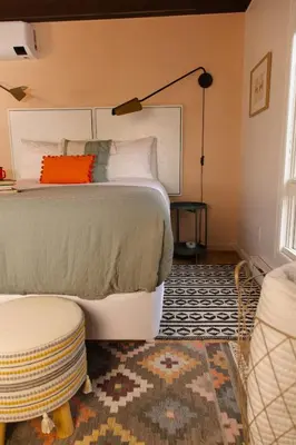 a bedroom with a bed and a lamp and a rug at Lake Naomi Chalet - 2hrs from NYC in Pocono Pines